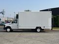 A 2008 Ford Econoline box truck with a white exterior and a flatbed design is parked on a concrete surface