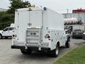 A white 2008 Ford F-450 SD with a large enclosed box in the back and steps leading up to the rear door