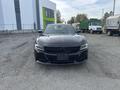 A 2015 Dodge Charger in black with a sleek design and prominent grille facing forward