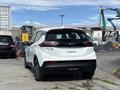 2023 Chevrolet Bolt EV in white with a sleek design visible from the rear showing distinctive taillights and a modern rear profile