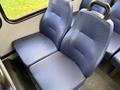 Two blue fabric seats in a bus or van, featuring a contoured design and armrests on the sides