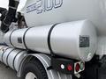 A silver tank mounted on a 2006 Sterling L7500 truck featuring labels and a strap for secure attachment