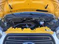 The image shows the engine compartment of a 2017 Ford Transit-350 with a yellow hood lifted revealing various engine components and fluids