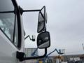 A 2013 Freightliner 114SD truck with two side mirrors prominently displayed in the foreground showing the truck's profile and reflective surfaces