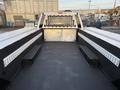 A 2018 Ford F-350 truck bed featuring black rubber flooring and metal side panels with built-in compartments