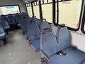 Interior of a 2017 Chevrolet Express showing several rows of blue upholstered seats with seat belts and a spacious layout