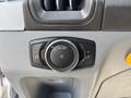 A control panel in a 2018 Ford Transit-350 featuring a circular dial for headlight settings and buttons for additional features