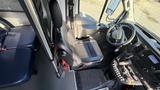 Interior view of a 2021 Ford Transit showing the driver's seat dashboard and steering wheel with controls and a gear shift