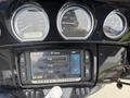 A 2017 Harley-Davidson FLHTKL featuring a black dashboard with gauges and an infotainment screen displaying radio options and time