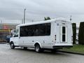 A white 2013 Chevrolet Express shuttle bus with large windows and wheelchair accessibility features