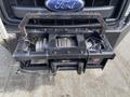 Front view of a black winch mounted on a 2015 Ford F-550 truck grille with visible mechanical components and wiring