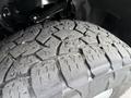 A close-up view of a rugged tire from a 2021 Ford F-150 showing detailed tread patterns and some wear indicating usage