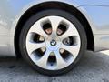 A close-up view of a silver 2004 BMW 6-Series wheel featuring a distinctive multi-spoke design and the BMW logo in the center
