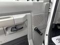 Close-up of the interior door handle and window crank of a 2014 Ford E-350 with a textured door panel in gray color