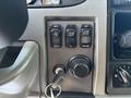 Dashboard controls of a 2015 Peterbilt 337 including buttons for cruise control and an ignition system with a key and assorted dials for adjustments