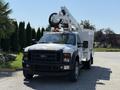 A 2008 Ford F-550 truck equipped with a hydraulic bucket lift and a utility body is parked with its lift fully extended