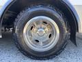 Close-up of a shiny alloy wheel with a rugged Nokian tire labeled Outpost AT on a 2017 Chevrolet Express