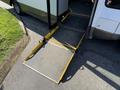 A yellow wheelchair ramp extended from the side of a 2020 Chevrolet Express van