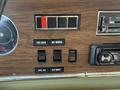 The dashboard of a 1976 GMC Motorhome featuring various switches and gauges including fuel controls and a radio interface