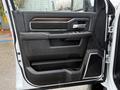Interior door panel of a 2024 RAM 5500 featuring a sleek design with wood and metallic accents and controls for windows and locks