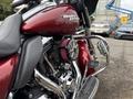 A 2009 Harley-Davidson Road King with a maroon paint job features a chrome engine and a custom air filter mounted on the side