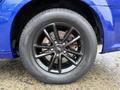 A close-up of a black alloy wheel on a blue 2020 Dodge Grand Caravan featuring a Goodyear tire
