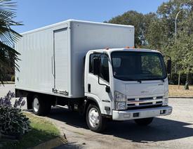 A 2012 Isuzu NPR HD box truck in white with a large cargo area and roll-up door on the side