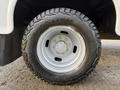A close-up of a black tire mounted on a silver wheel with a five-bolt pattern designed for a 2018 Ford F-350