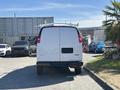 A white 2019 GMC Savana van viewed from the rear with its doors closed and a GMC logo visible