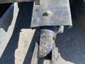 Close-up of a 2022 John Deere hitch attachment featuring a metal plate with a bolt and a spherical joint connection with visible wear and rust