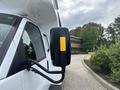 A side view mirror of a 2020 Chevrolet Express with a black casing and a yellow strip attached to it
