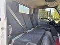 Interior of a 2018 Hino 195 truck featuring two padded seats with seat belts and a console between them