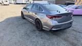 A 2018 Hyundai Sonata in silver with black wheels parked on gravel showing a sleek design and modern rear lights
