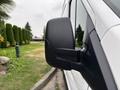 A close-up of the side mirror of a 2020 Ford Transit 250 showcasing its black casing and design