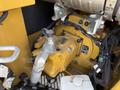 Close-up view of the hydraulic pump of a 2022 Caterpillar 306 featuring yellow components and various tubes and wires connected to the machinery