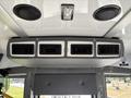 The interior overhead compartment of a 2020 Chevrolet Express featuring ventilation vents and speaker grills