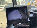 A dashboard monitor displaying a rearview camera feed of a concrete surface