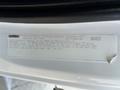 A close-up of a white Freightliner M2 106 truck with a focus on the vehicle noise emission control information label