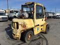 A 1993 Hyster H80XL forklift with a yellow exterior showing signs of wear and rust, featuring a cabin, large front tires, and an engine compartment on the rear