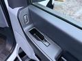 Interior door panel of a 2023 Ford F-250 featuring a window control switch and a storage compartment
