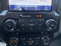 Dashboard controls of a 2022 Ford F-350 SD featuring audio and climate control buttons along with multimedia options