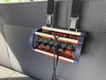 A control panel with multiple switches and buttons mounted on the back of a vehicle seat