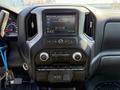 The interior dashboard of a 2022 GMC Sierra 1500 featuring a digital display audio system with control buttons and air conditioning settings