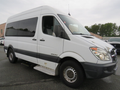 A white 2009 Dodge Sprinter Van with side windows and a step at the door