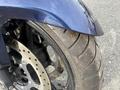 Close-up of a blue 2016 Yamaha FJR1300AE motorcycle front fender and wheel showing the tire tread and brake components