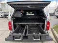 A 2018 Chevrolet Colorado with an open truck bed showing sliding trays for storage and accessories inside the cargo area