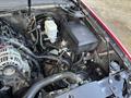 The engine compartment of a 2011 Chevrolet Avalanche showing various components including the battery coolant reservoir and wiring harnesses