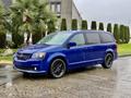 A blue 2020 Dodge Grand Caravan with black rims parked on a wet surface