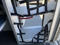 A 2013 Chevrolet Express interior featuring a door with various black straps and a red handle for securing items inside