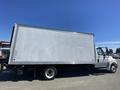 A 2014 International TerraStar truck with a large white cargo box on its back and wheels visible on the left side